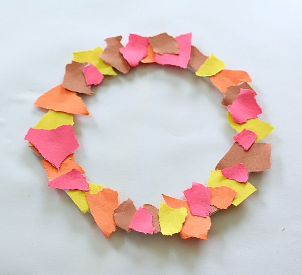Glue torn pieces of construction paper onto the circle