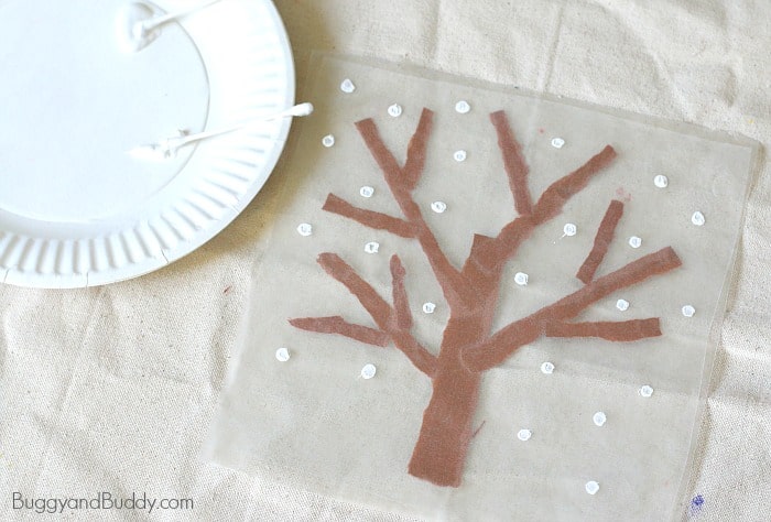 use a q-tip (cotton swab) and tempera paint to make snowflakes on your suncatcher