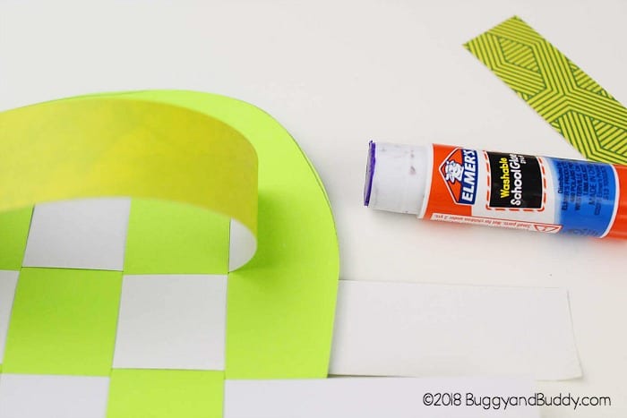 glue the woven paper strips down to your apple shape
